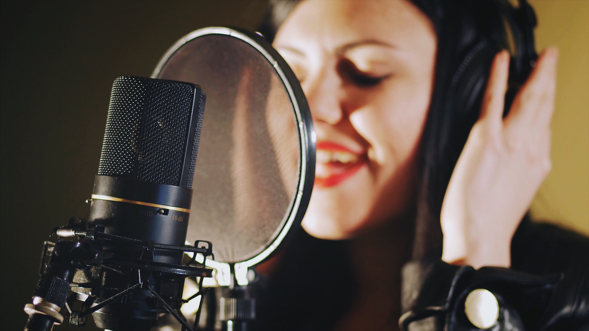 Expressive woman singing in music studio, recording song