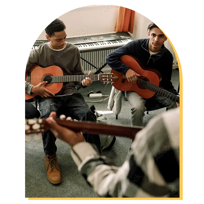 Three people sit in a room holding acoustic guitars, appearing to be in a music class or group lesson. Two are looking at the instructor, whose back is to the camera—an inviting scene for those seeking music lessons in Westchase.